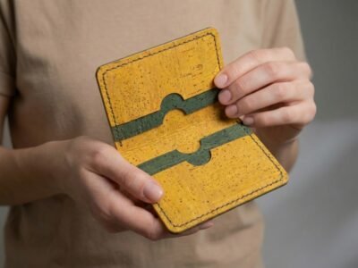 Yellow and green cork cardholder wallet being held by a model